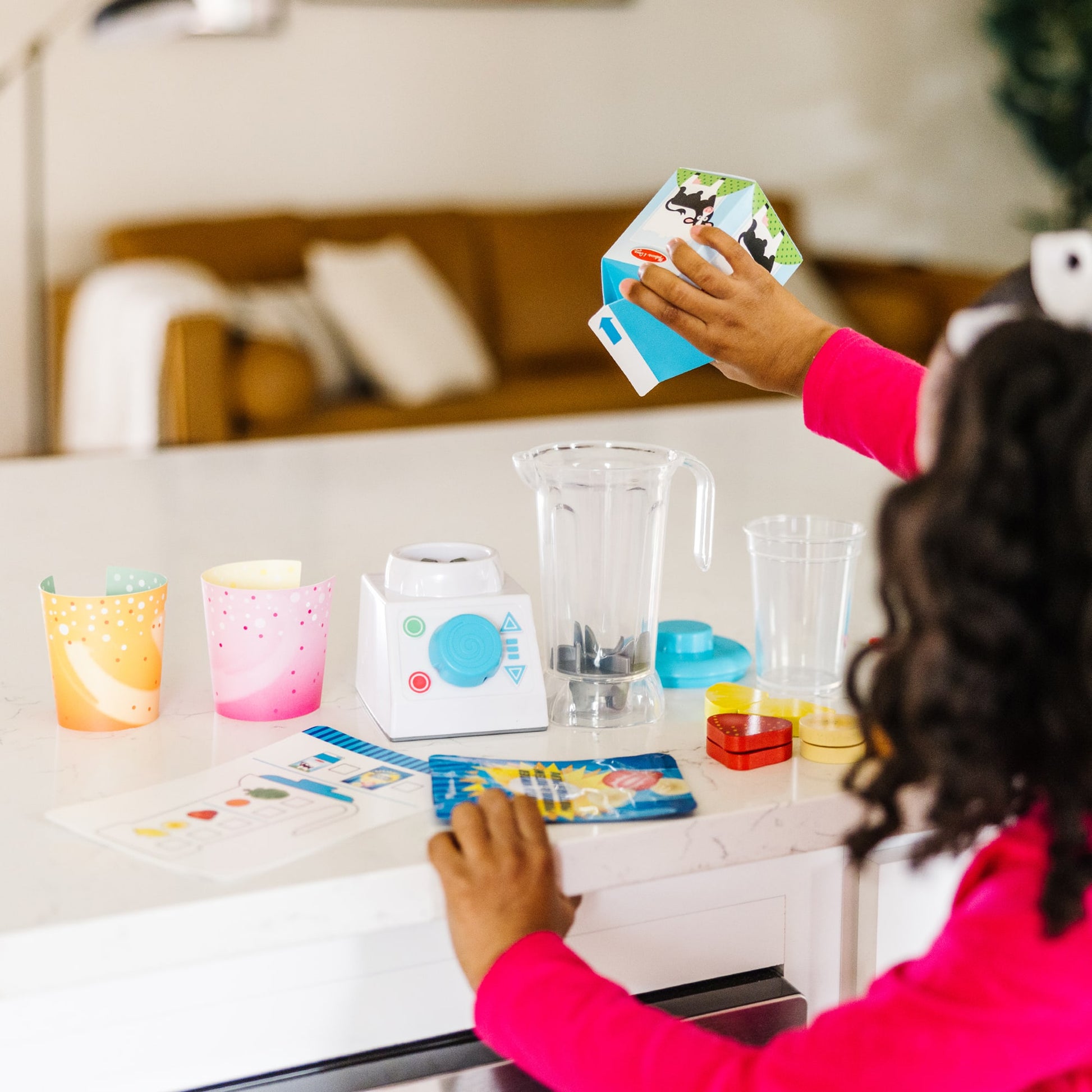 Person playing with colorful card games at a kitchen counter