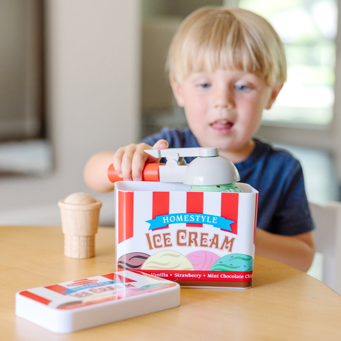 Toy ice cream set with cones, a carton, and an ice cream scoop on a white background