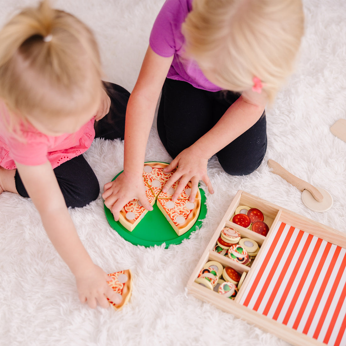 Wooden toy pizza set with slices and a tray on a white background