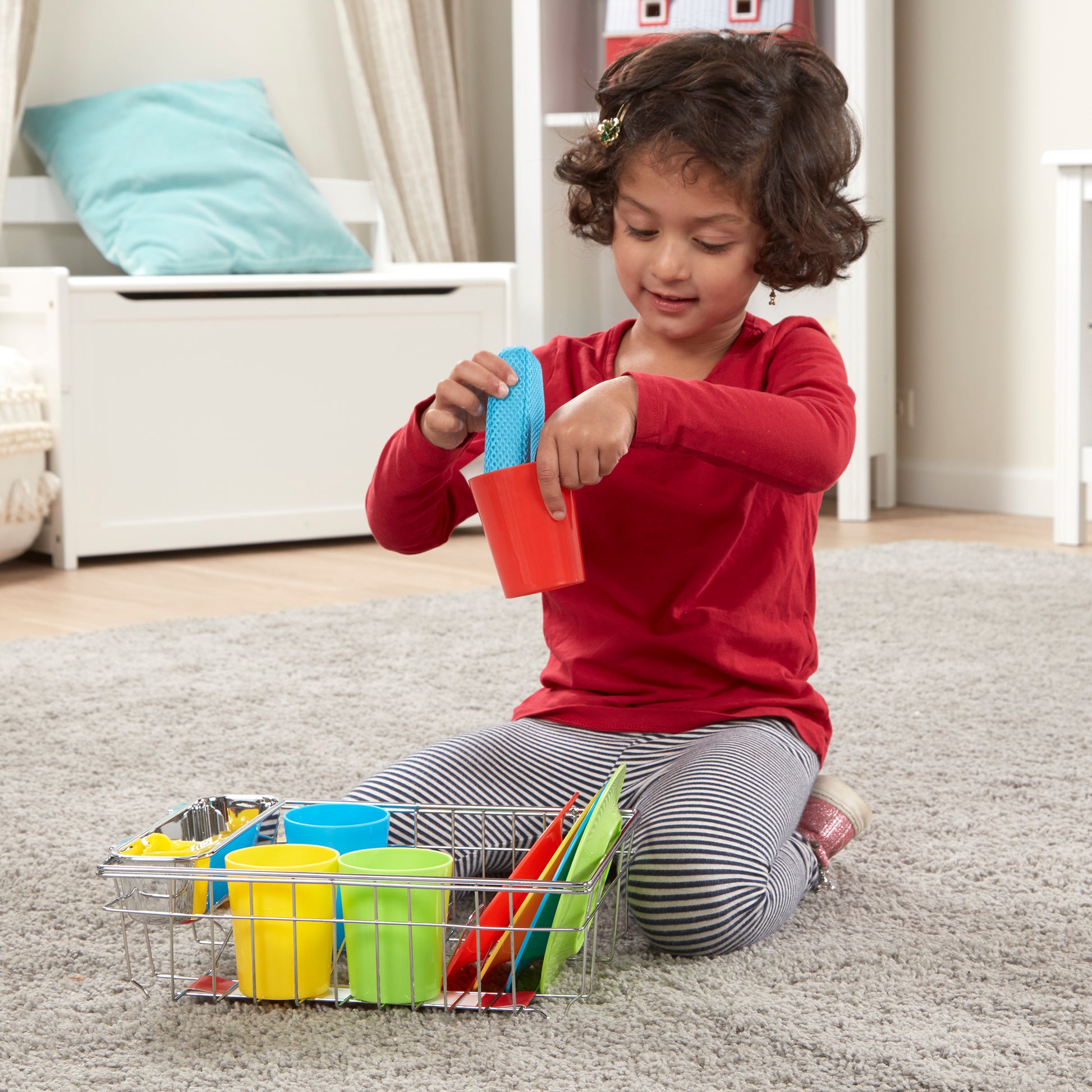 Child playing with colorful cups and a basket on the floor