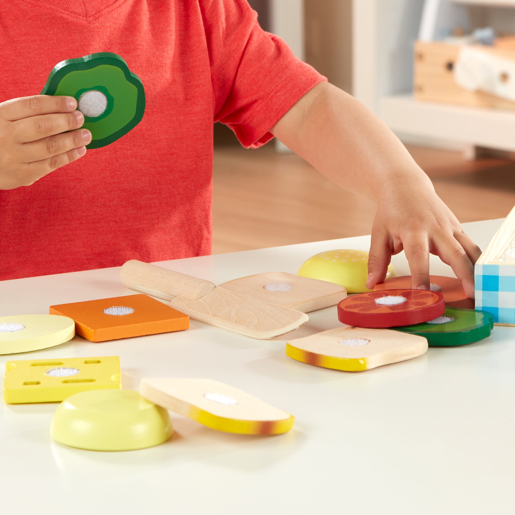 Child playing with colorful wooden shape sorting toys on a table.