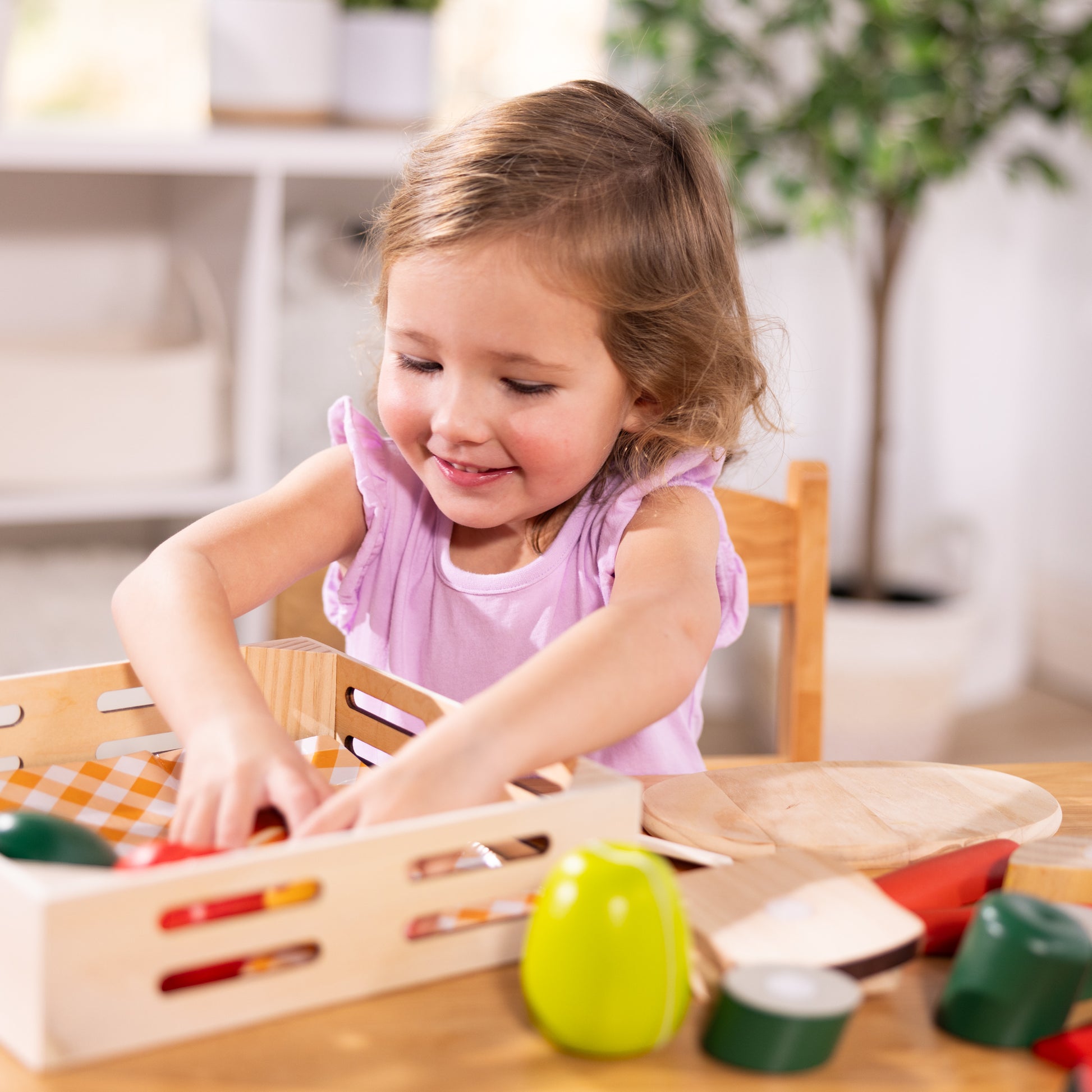 Child playing with a wooden toy on a table in a bright room.