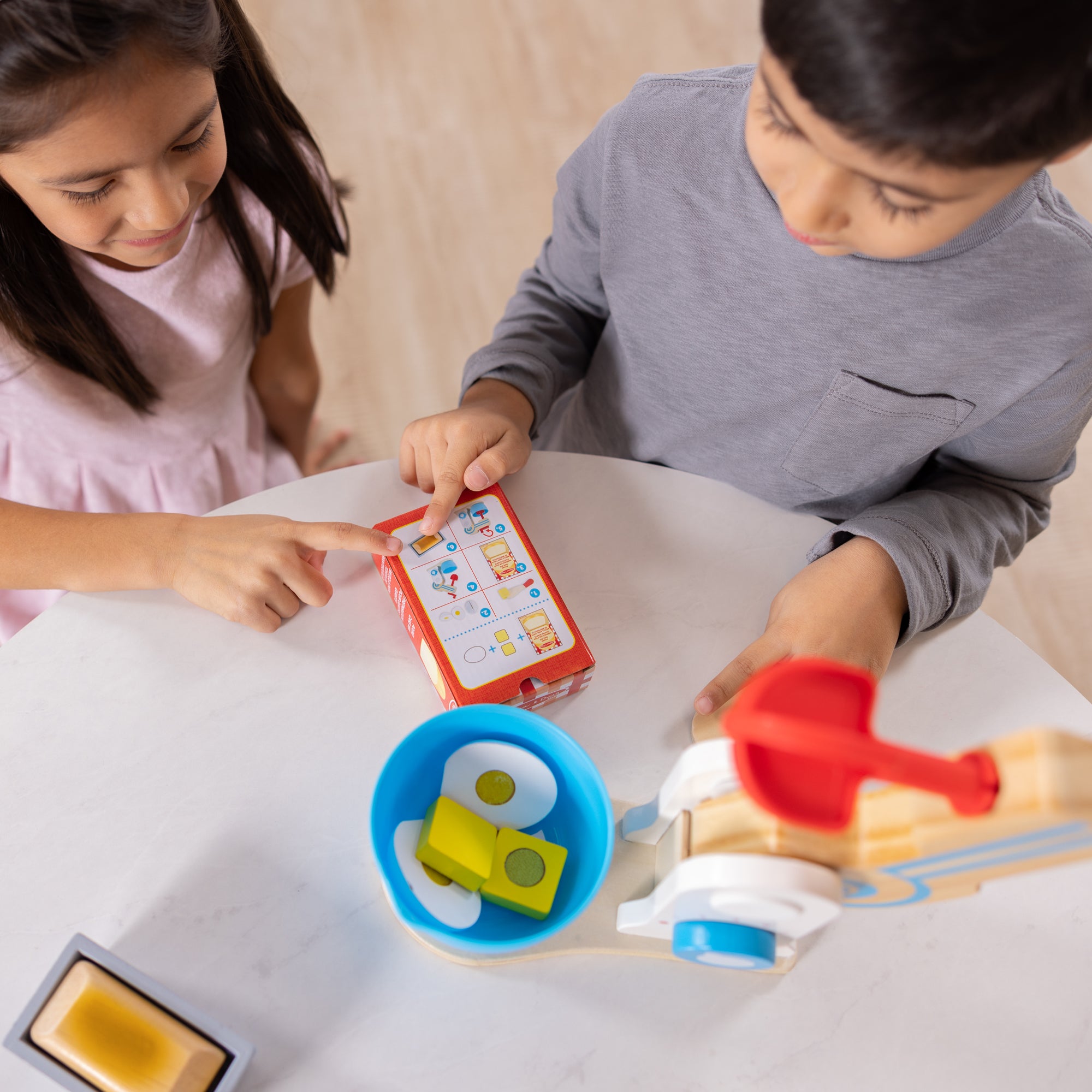 Two children playing with educational toys on a table.