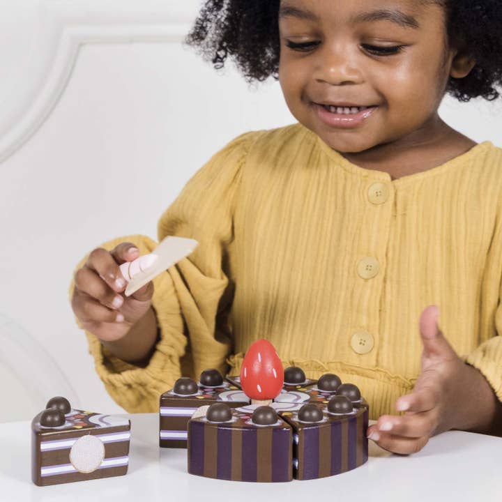 Child playing with Chocolate Gateau Sliceable Cake 