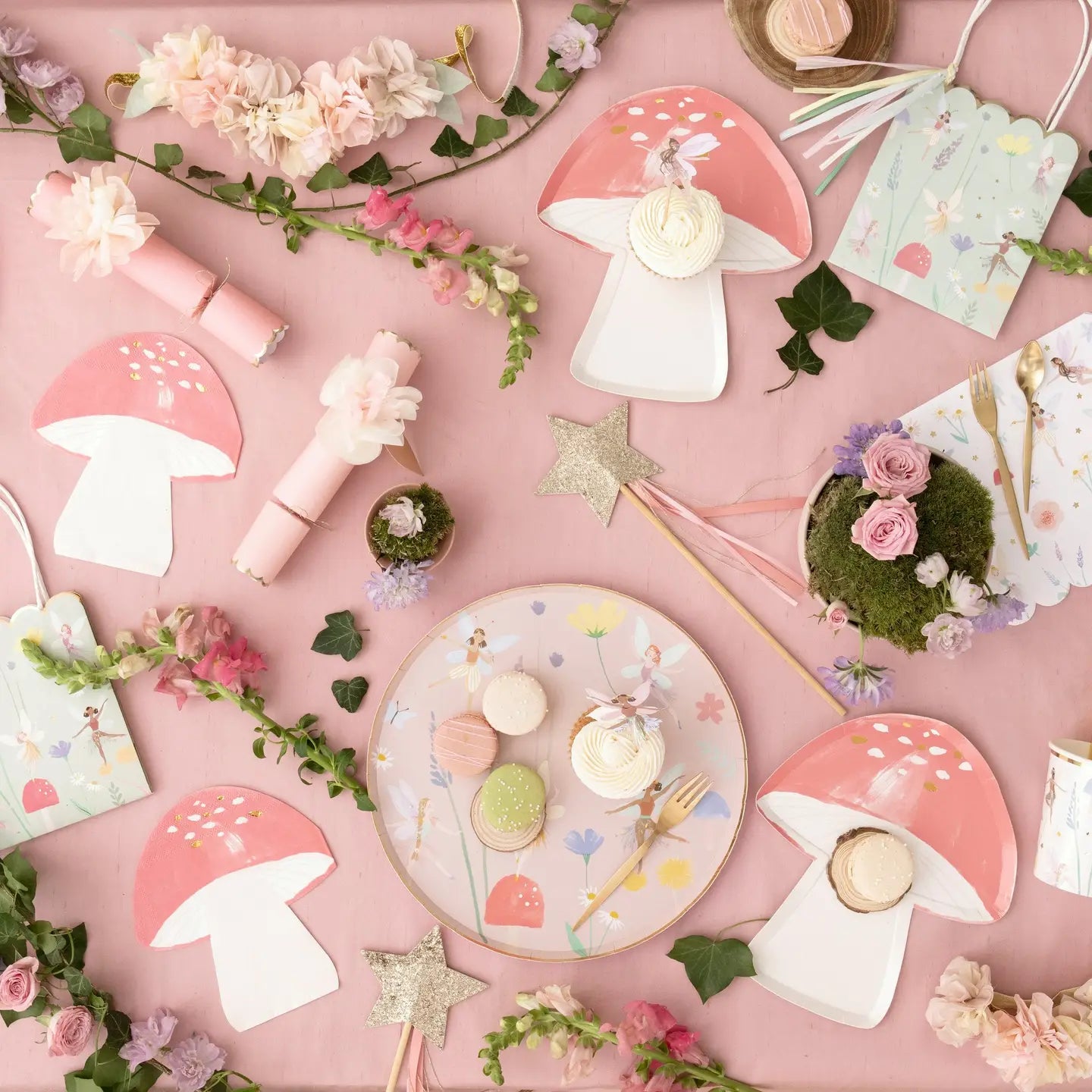 Pastel-colored party supplies including mushrooms, flowers, and decorative items on a pink background