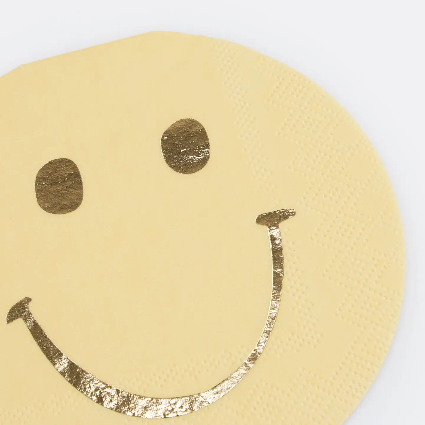 Gold smiley face on a beige background