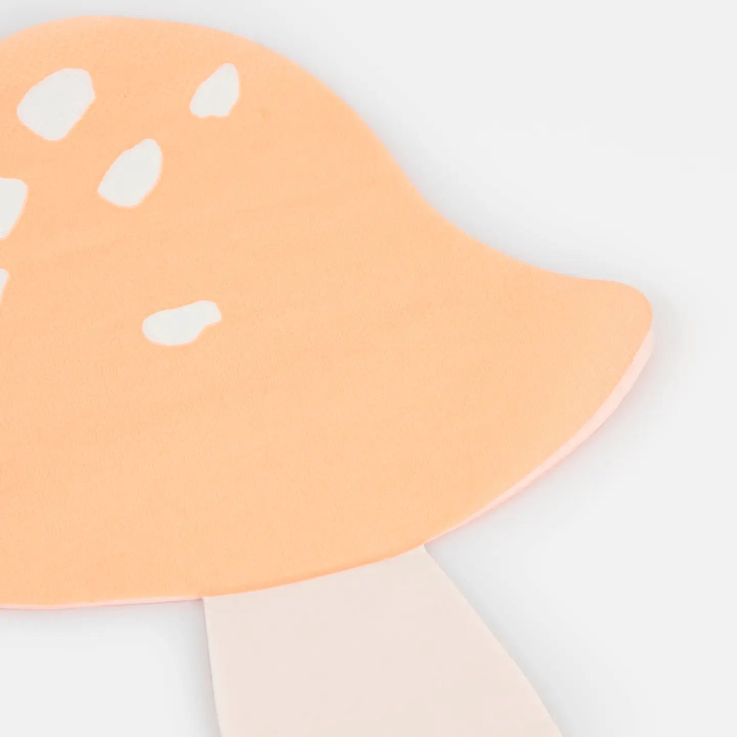 Close-up of a peach-colored mushroom-shaped object on a light gray background
