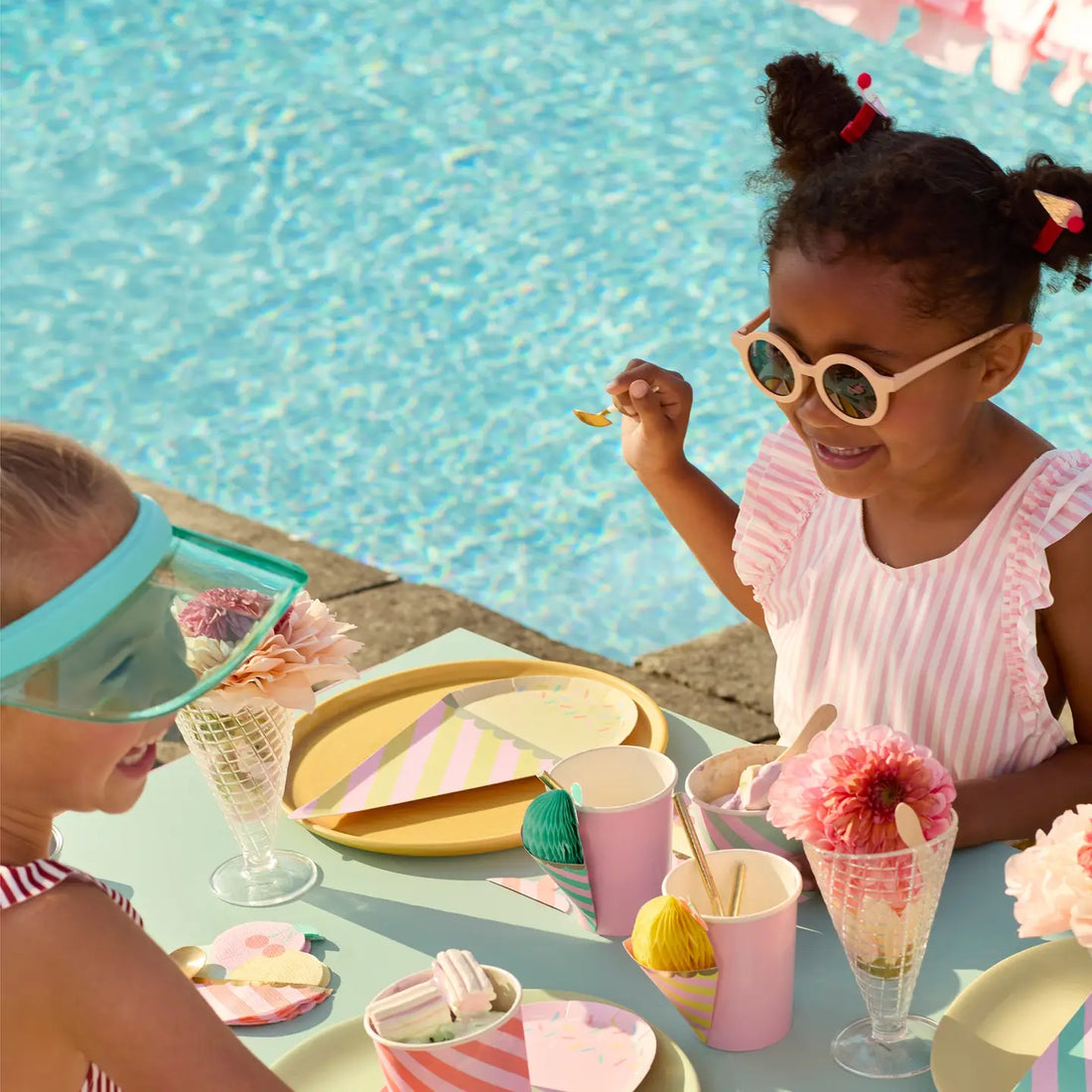 Colorful ice cream cone-shaped party plates with striped patterns and gold accents on a white background.