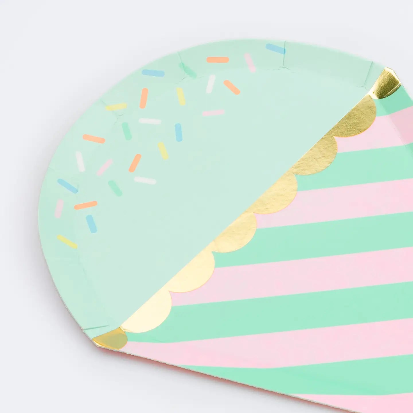 Colorful paper plate with striped and sprinkles design on a white background