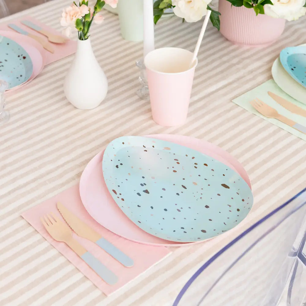 Egg-shaped paper plate with speckled pattern on a white background