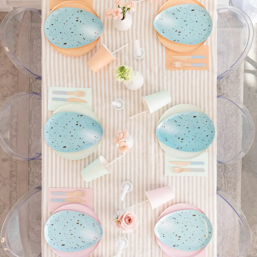 Set of blue and pink bowls with utensils on a striped surface